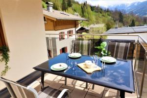 滨湖采尔Chalet Schmittenbach - Pinzgau Holidays的阳台上配有蓝色的桌椅