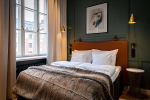 赫尔辛基Scandic Grand Central Helsinki的一间卧室配有一张带白色床单的床和一扇窗户。