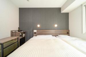 广岛Super Hotel Hiroshima Yagenboridori的一间卧室配有一张大床和一张书桌