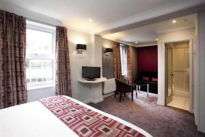 诺丁汉St James Hotel; BW Premier Collection的酒店客房配有一张床、一张书桌和一台电视。