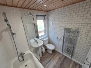 彭里斯Park Lodge的浴室配有卫生间、盥洗盆和浴缸。