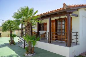 塞奥洛戈斯M&B Luxury House的房屋前方设有棕榈树阳台
