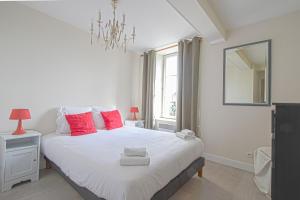 贝叶IKE'S Deluxe APARTMENT in Bayeux的卧室配有带红色枕头的大型白色床
