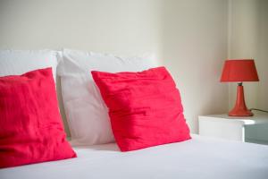 贝叶IKE'S Deluxe APARTMENT in Bayeux的一张带两个红色枕头和红灯的床