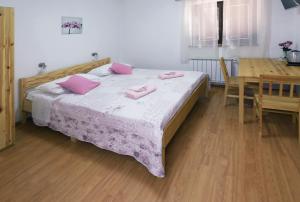 波斯托伊纳萨那波尔住宿加早餐旅馆的一间卧室配有带粉红色枕头的床。