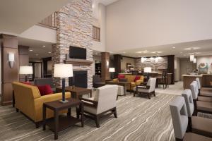 索斯盖特Staybridge Suites - Southgate - Detroit Area, an IHG Hotel的一个带沙发和椅子的酒店大堂