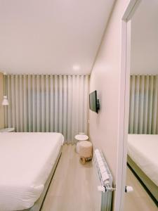 Rego da LeirosaMaré Viva Bed & Breakfast的一间卧室配有两张床,内设长凳