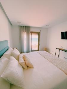 Rego da LeirosaMaré Viva Bed & Breakfast的卧室配有带枕头的大型白色床