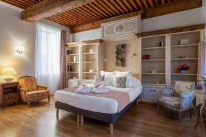 罗讷河畔沙斯LE DOMAINE DE GORNETON的一间卧室配有一张大床和两把椅子