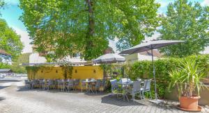 奥根Landgasthof zur Sonne的一间带桌椅和遮阳伞的餐厅