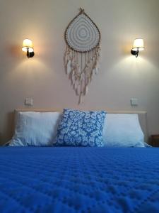 科武港Quartos Abelha的卧室配有蓝色的床,墙上有两盏灯
