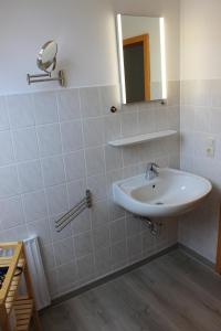 Sulsdorf auf FehmarnGästehaus Sulsdorf - Adults only的白色的浴室设有水槽和镜子