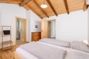 洛帕Apartment Ursula的卧室设有白色的床和木制天花板。