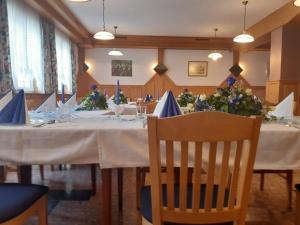 Sankt Johann im SaggautalGasthof Jauk-Hartner的用餐室配有长桌子、椅子和鲜花