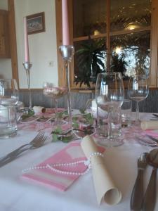 Sankt Johann im SaggautalGasthof Jauk-Hartner的一张桌子,上面有粉色和白色的桌布,上面有酒杯
