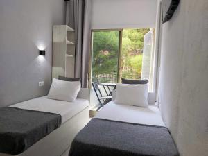 阿利坎特Casa Durán Alicante的两张床位于带窗户的房间内