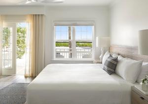 基韦斯特Parrot Key Hotel & Villas的白色的卧室设有一张大床和一个窗户