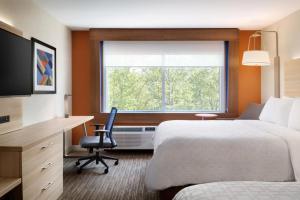 伊丽莎白Holiday Inn Express - Newark Airport - Elizabeth, an IHG Hotel的配有一张床、一张书桌和一扇窗户的酒店客房