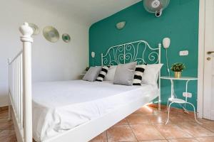 卡塔尼亚Palazzo Currò的一间卧室配有一张白色的床和绿色的墙壁
