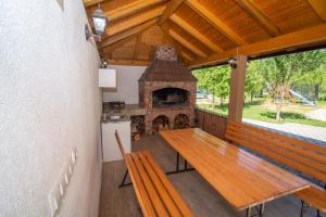 RačićHoliday Home Faruk的门廊配有木桌和壁炉