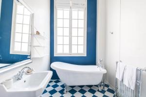 巴黎笑颜精品酒店的浴室配有白色浴缸和水槽
