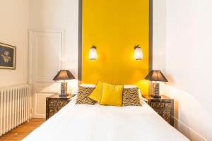 巴黎笑颜精品酒店的卧室配有白色床和黄色墙壁
