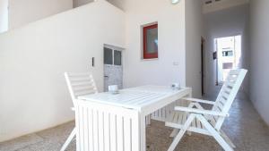 莱乌卡La Flor di Leuca的客房内的一张白色桌子和两把椅子