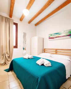 滨海波利尼亚诺C'era una Volta Apartments的一间卧室配有蓝色的床和2条毛巾
