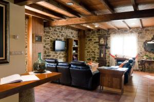 内格雷拉卡萨佛尔格乡村民宿的客厅配有皮椅和电视