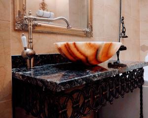 布拉索夫CezAri ApartHotel的浴室的台面上有一个碗水槽
