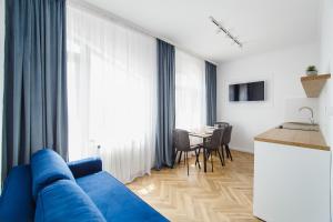 奥拉迪亚Rya Residence Oradea的客厅配有蓝色的沙发和桌子