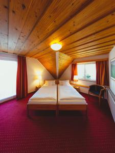 福尔巴赫Hotel am Mühlbach的卧室设有一张木制天花板上的大床