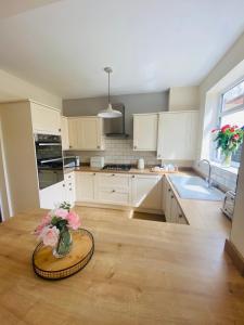斯卡伯勒Acacia Breezes - Delightful Scarborough Semi的厨房配有白色橱柜和鲜花桌