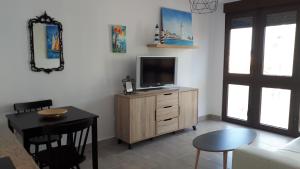 马拉加Malagueta & Port的客厅配有木柜上的电视