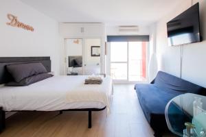 贝纳尔马德纳Dream Studio in Benalmadena Costa del Sol的一间卧室配有一张大床和一张蓝色的沙发