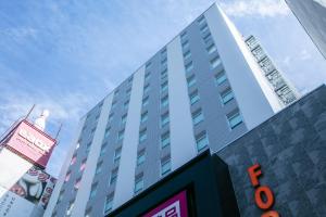 大阪Hotel Forza Osaka Namba的前面有标志的高楼