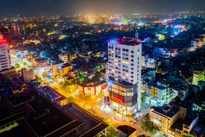 Nam ÐịnhSOJO Hotel Nam Dinh的夜晚城市的空中景观