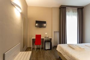 真加Hotel Terme di Frasassi的酒店客房配有红色椅子和书桌