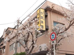 大阪今里旅馆的树前有标志的建筑物