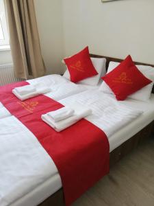 弗兰季谢克矿泉镇Pension VIDHOUS 2的一张铺有红白床单和红色枕头的床
