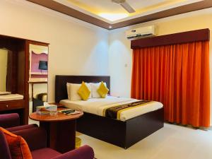 拉斯阿尔卡麦Al Nakheel Hotel Apartments的酒店客房,配有床和红色窗帘
