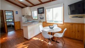 波塔灵顿Bellarine Bayside Portarlington的厨房配有白色的桌椅和水槽