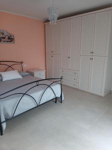 科皮托Nel cuore di Coppito的一间卧室配有一张床、白色橱柜和吊灯。