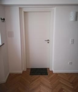 班贝格Ferienwohnung im Hain的铺有木地板的房间内的白色门