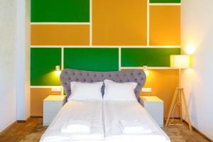 特尔古穆列什H11 Downtown Apartments的一间卧室配有一张带彩色墙壁的床