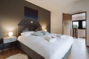 塞扎纳Apartma Ob stari murvi, Sežana的卧室配有一张带白色床单和枕头的大床。