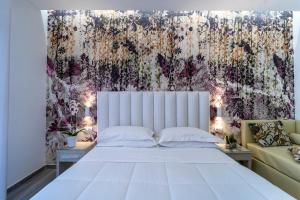 里米尼斯特拉多罗酒店的卧室配有一张白色的大床和一张沙发。