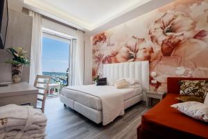 里米尼斯特拉多罗酒店的一间卧室设有一张床和鲜花墙