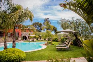 因佩里亚Leonardo Resort的庭院内一个带椅子和遮阳伞的游泳池