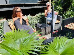 阿比让休闲酒店的两个妇女在花园里坐在椅子上